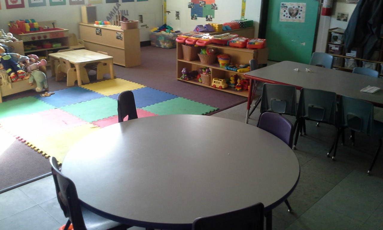 Classroom with tables, chairs, and colorful floor mats
