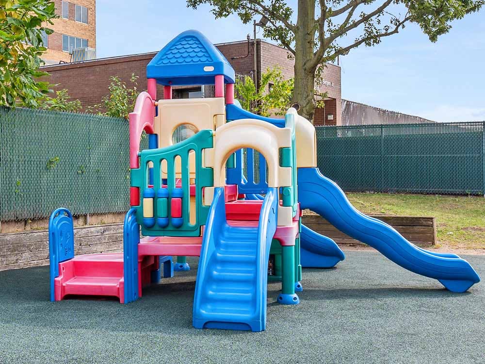 Colorful playground structure with slides and stairs on a soft surface