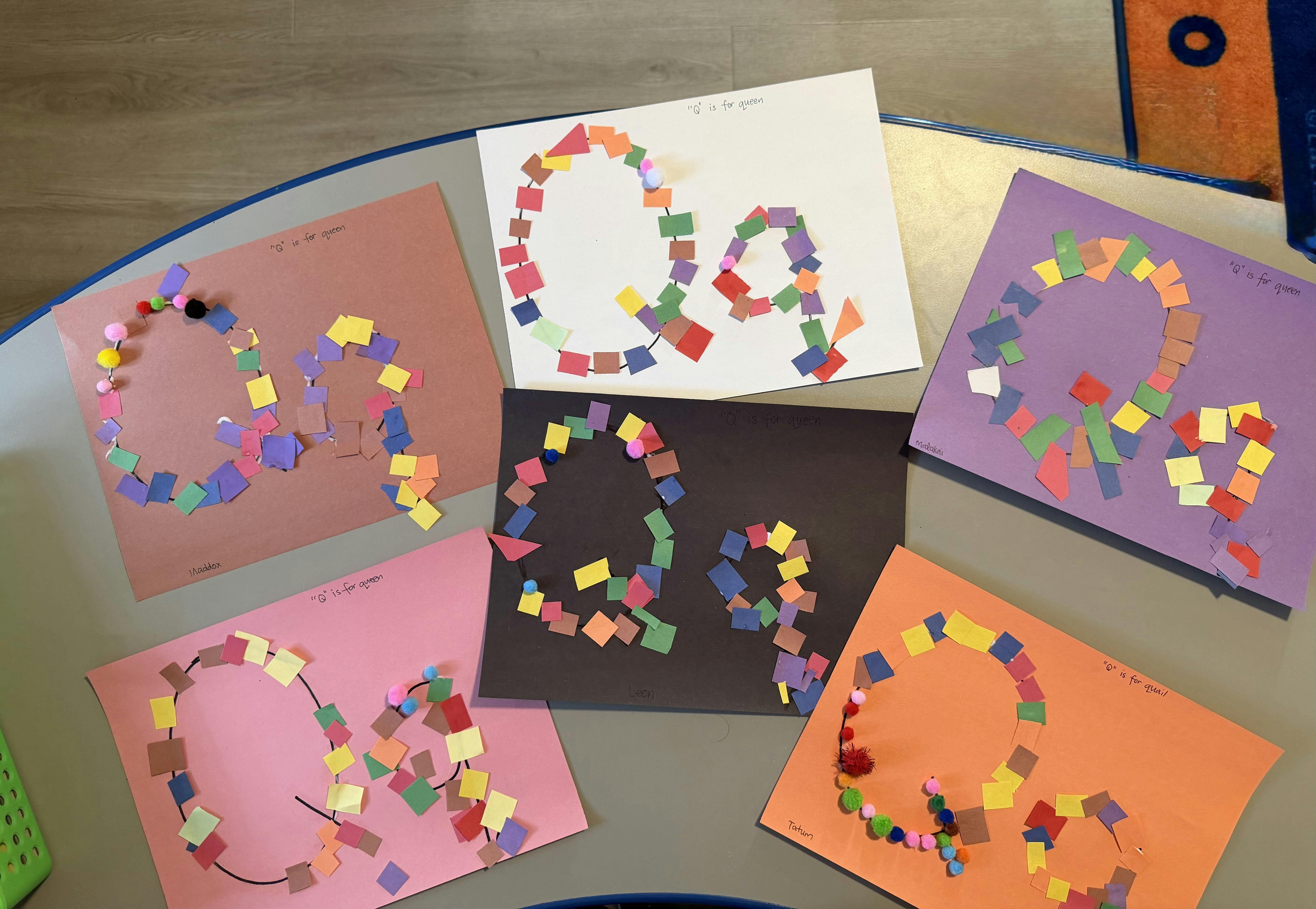 Colorful paper craft projects displaying the letter Q on a table