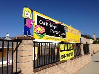 Oakridge Pre-School sign with a cartoon child and flower