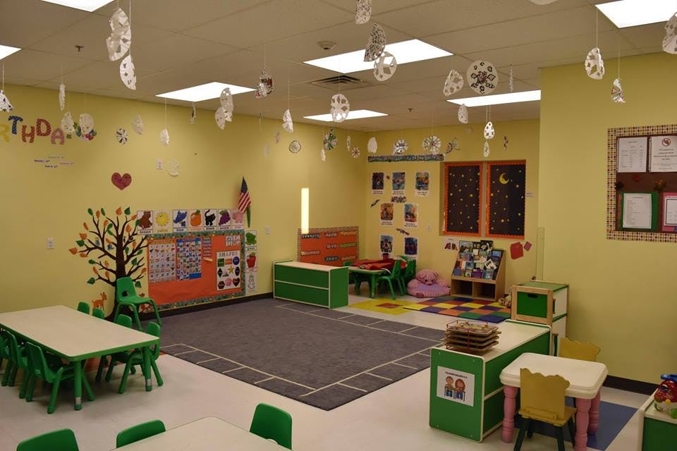 Empty classroom with small tables and chairs, decorated walls