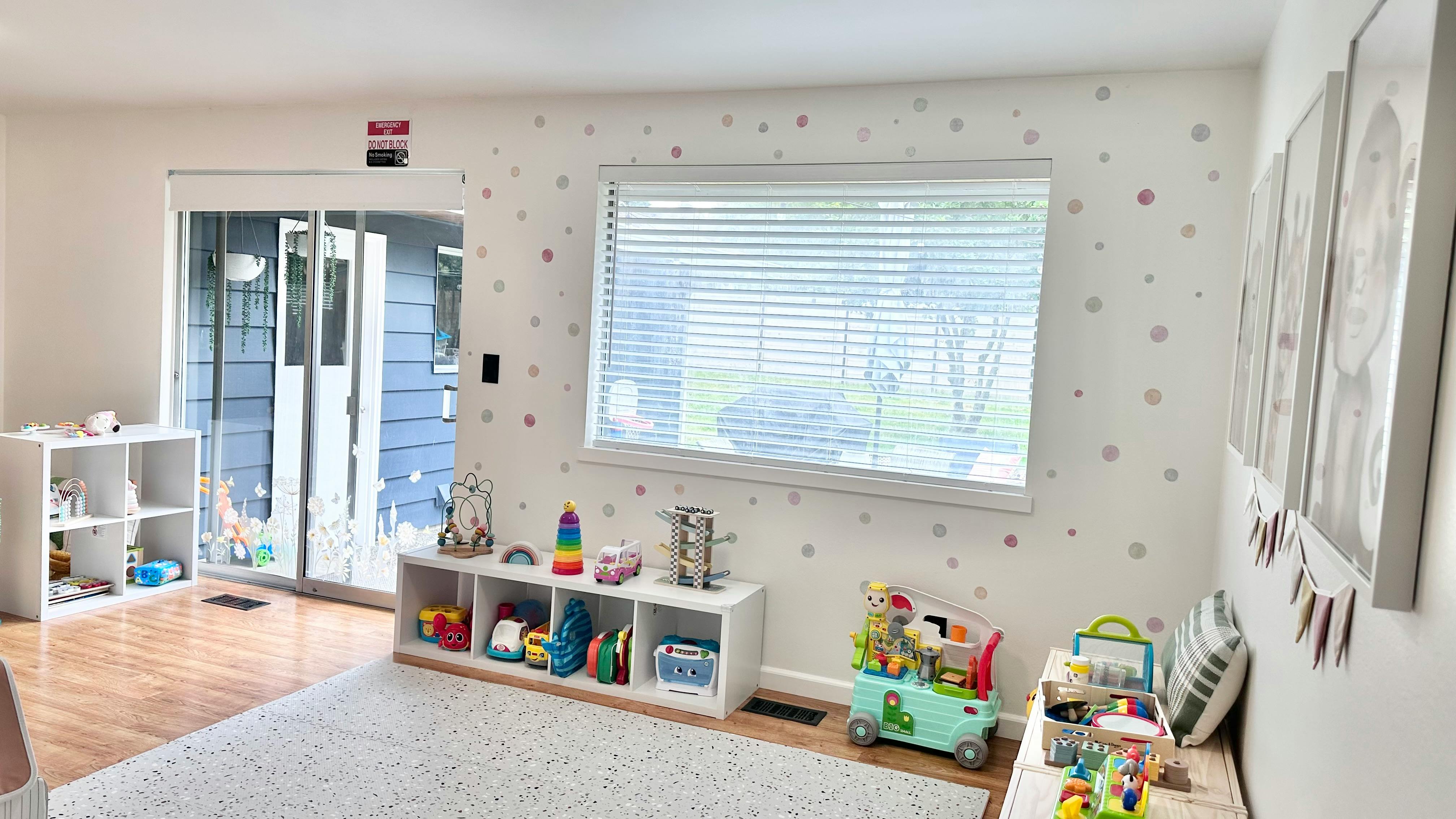 Playroom with toys on shelves and a window with blinds