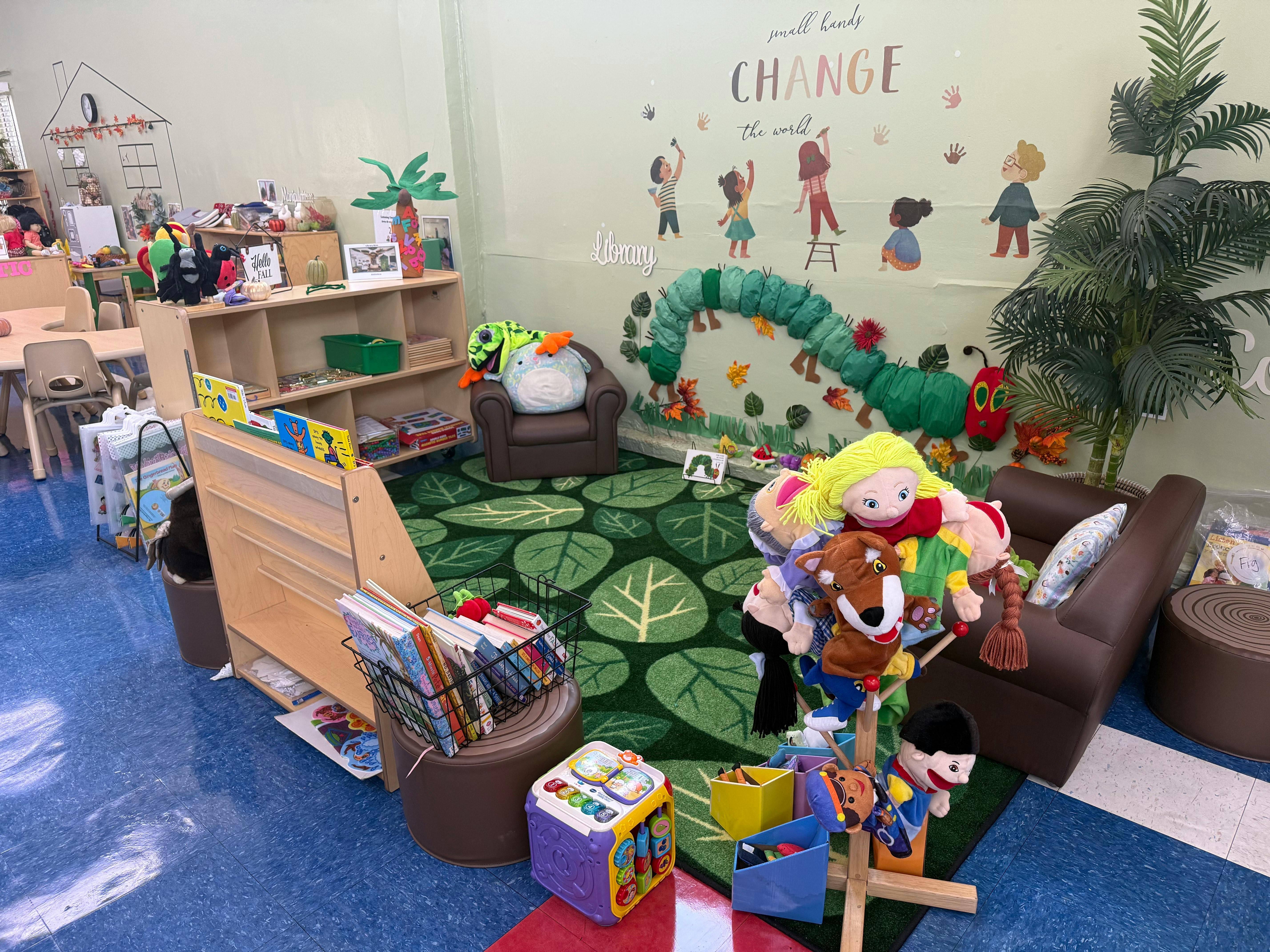 Children's reading corner with a leaf-patterned rug and stuffed animals
