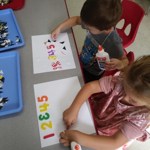 Two children doing crafts at a table