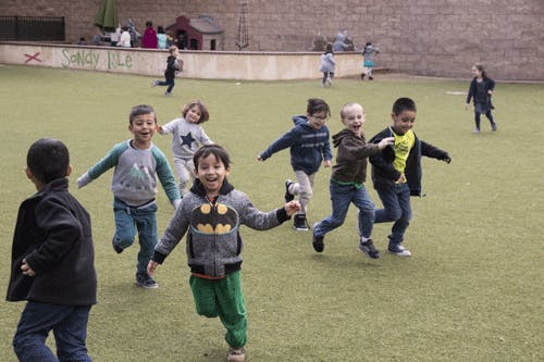 Group of children running on a grassy field