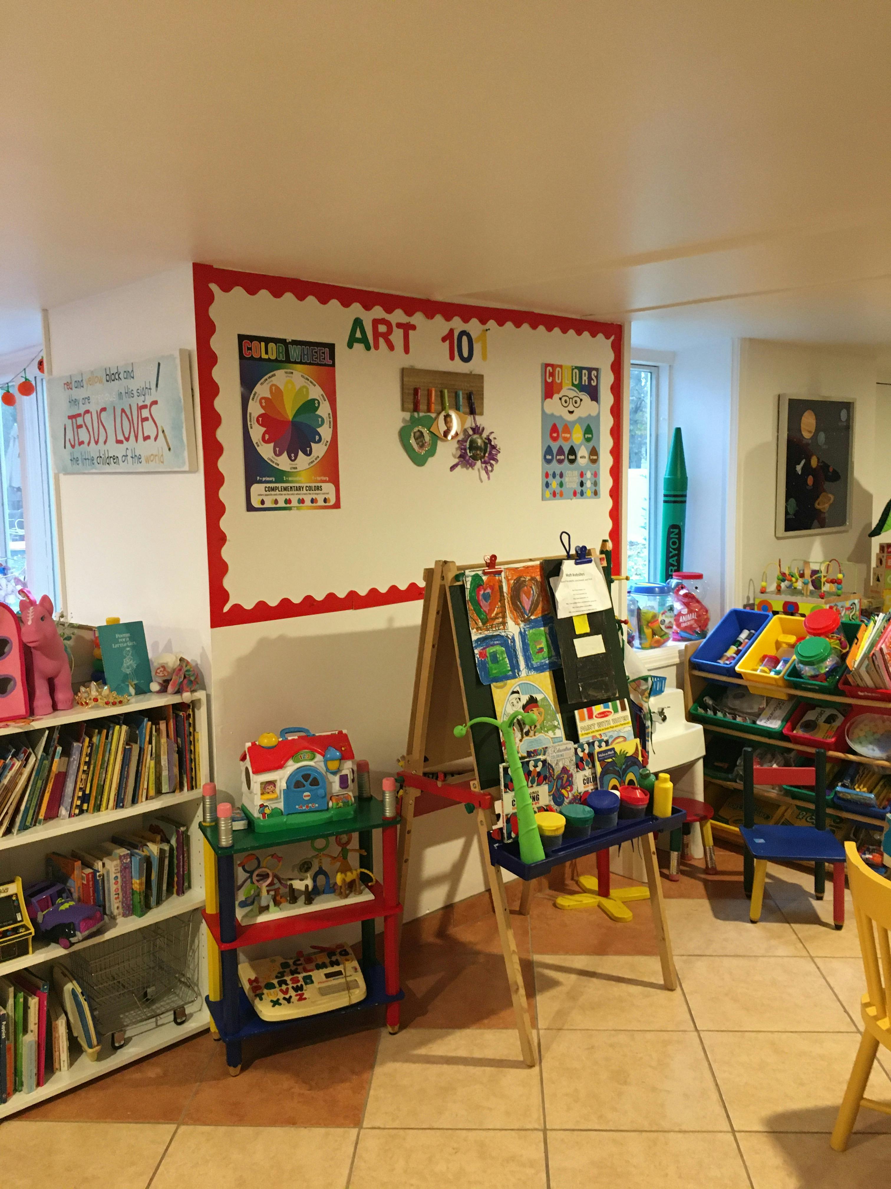 Children's art room with an easel, shelves of books, and art supplies