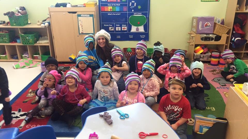 Adult and children wearing striped hats in a classroom
