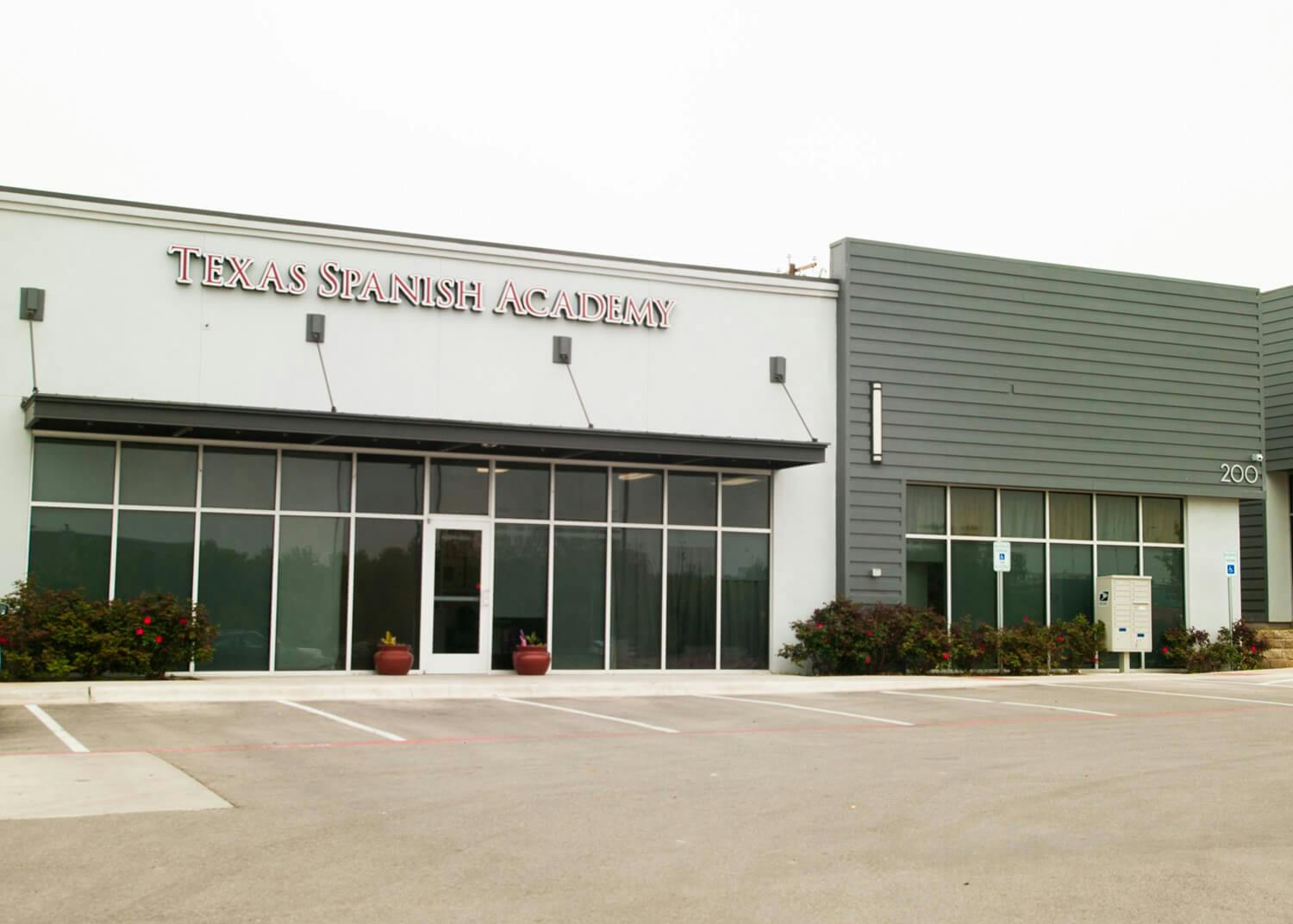 Building with "Texas Spanish Academy" sign above large windows