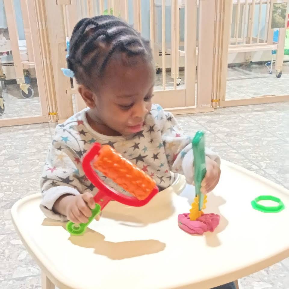 Child playing with colorful toys at a table