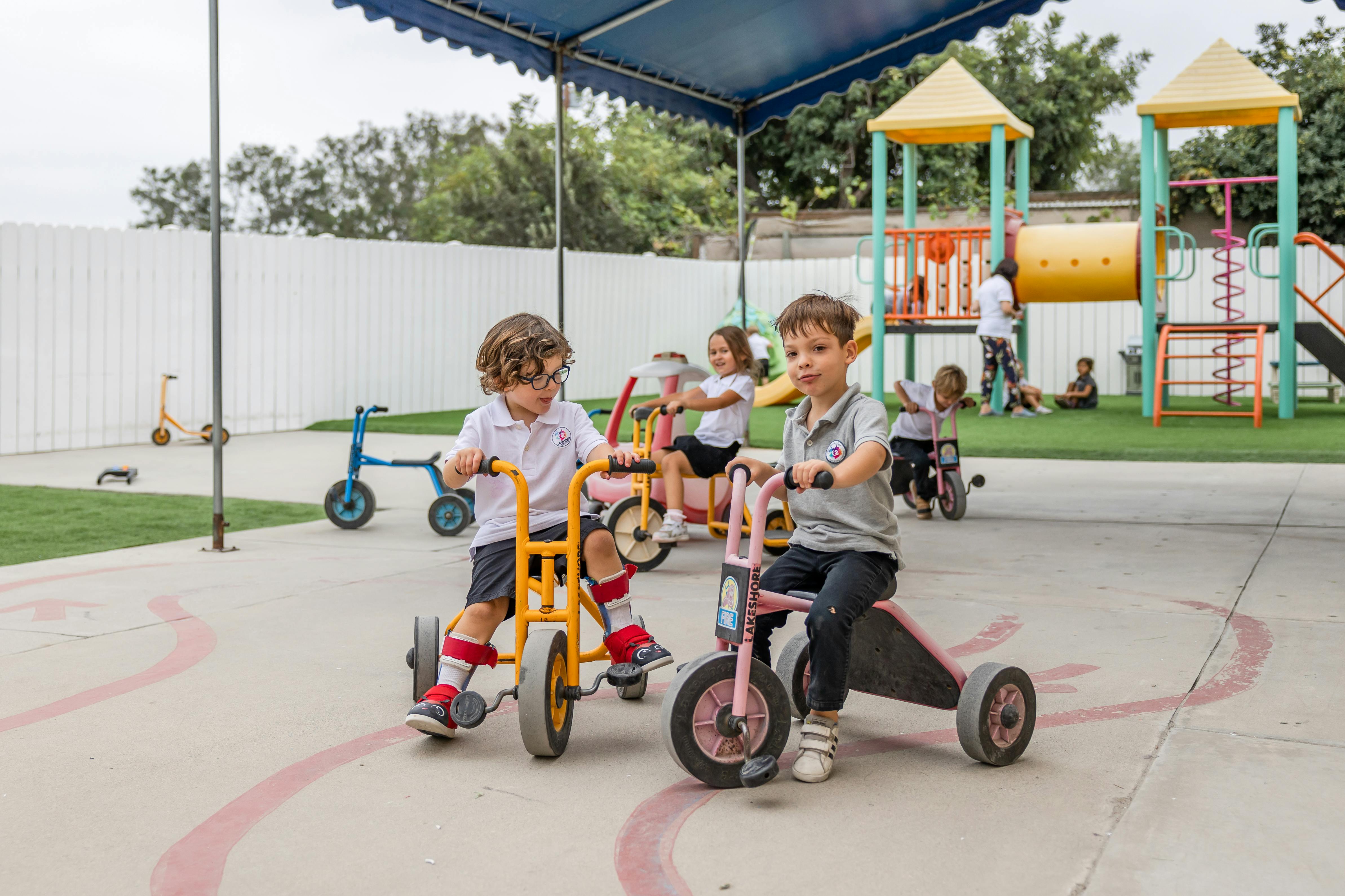 Children riding tricycles on a playground