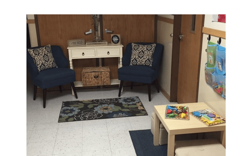 Two armchairs, a console table with a basket, and a small play table with puzzles