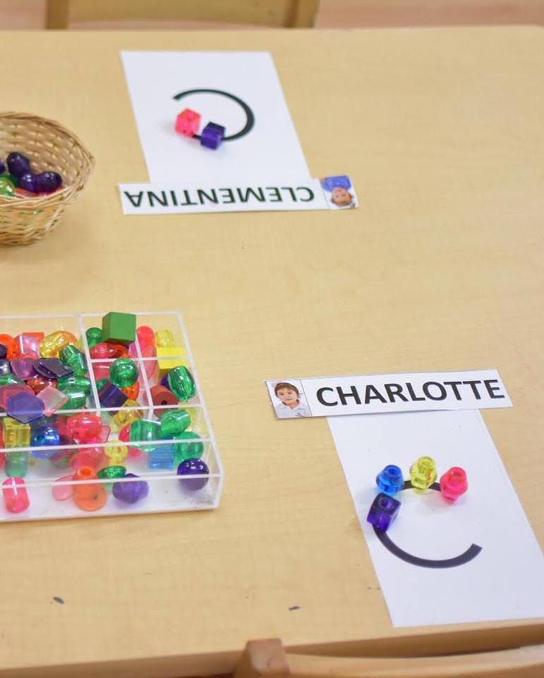 Beads on paper with names Clementina and Charlotte
