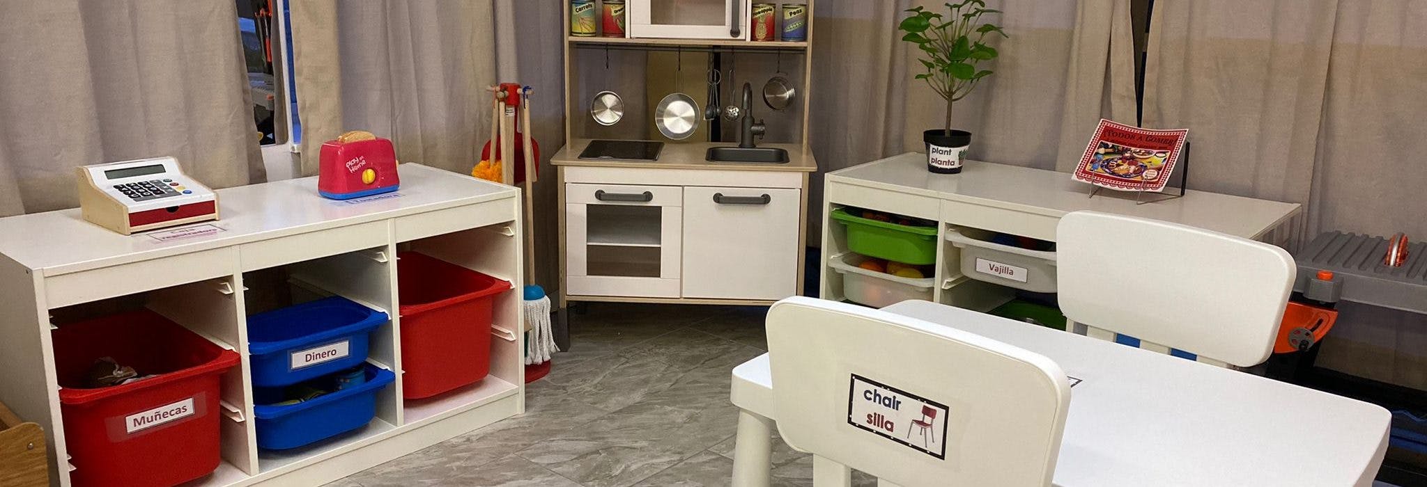 Children's play kitchen and store with toy food, register, and cleaning supplies