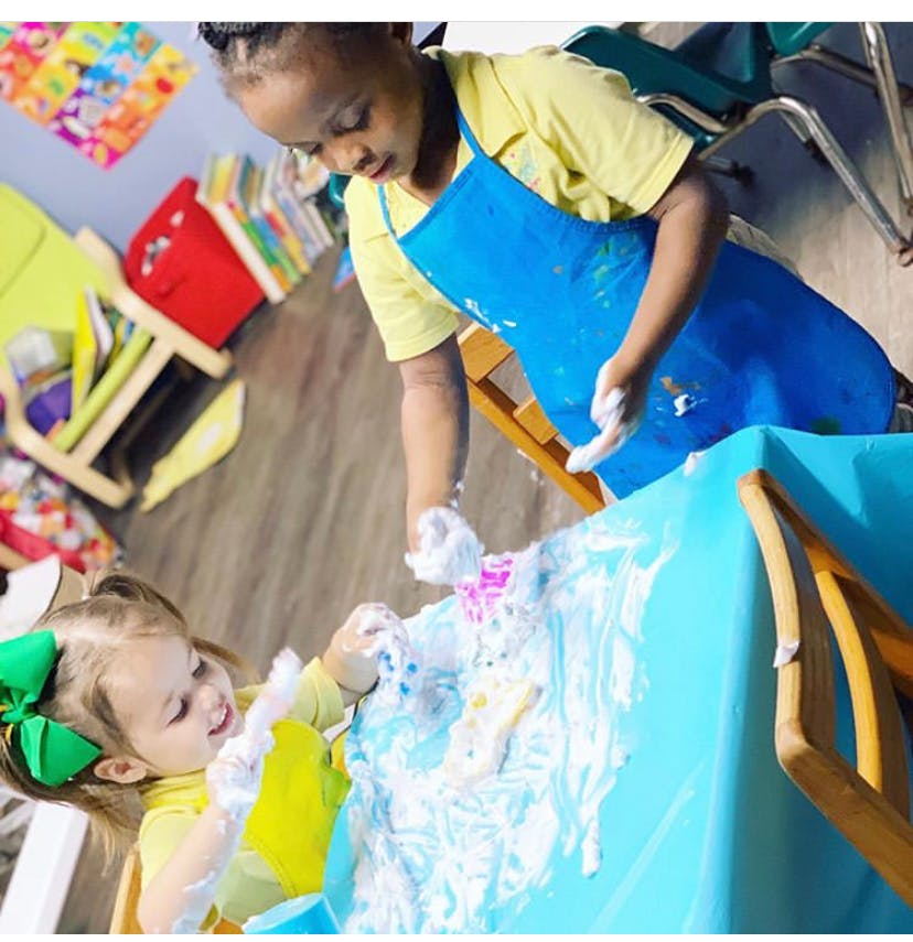 Two children playing with foam on a table