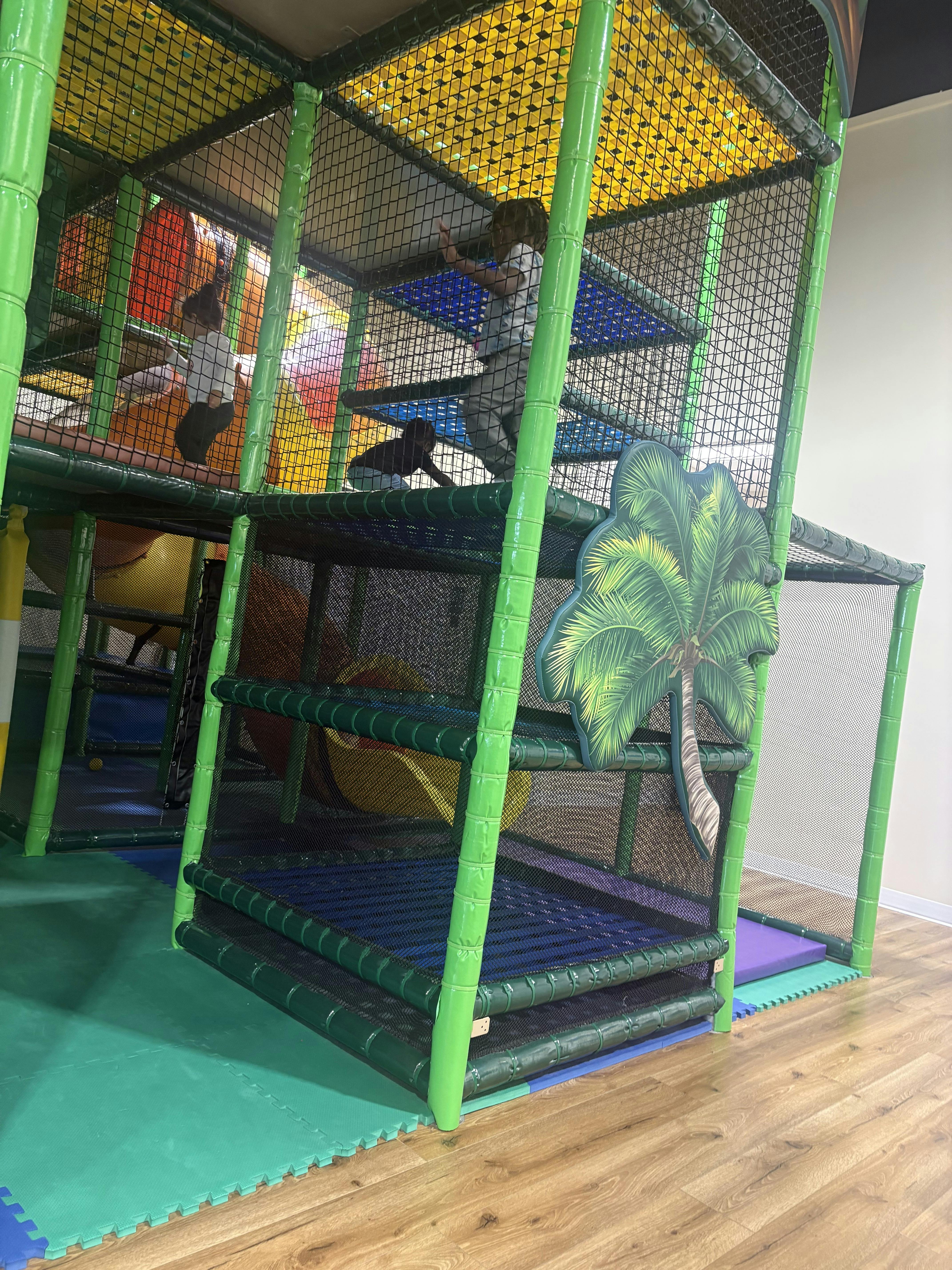 Children playing inside a large jungle gym structure