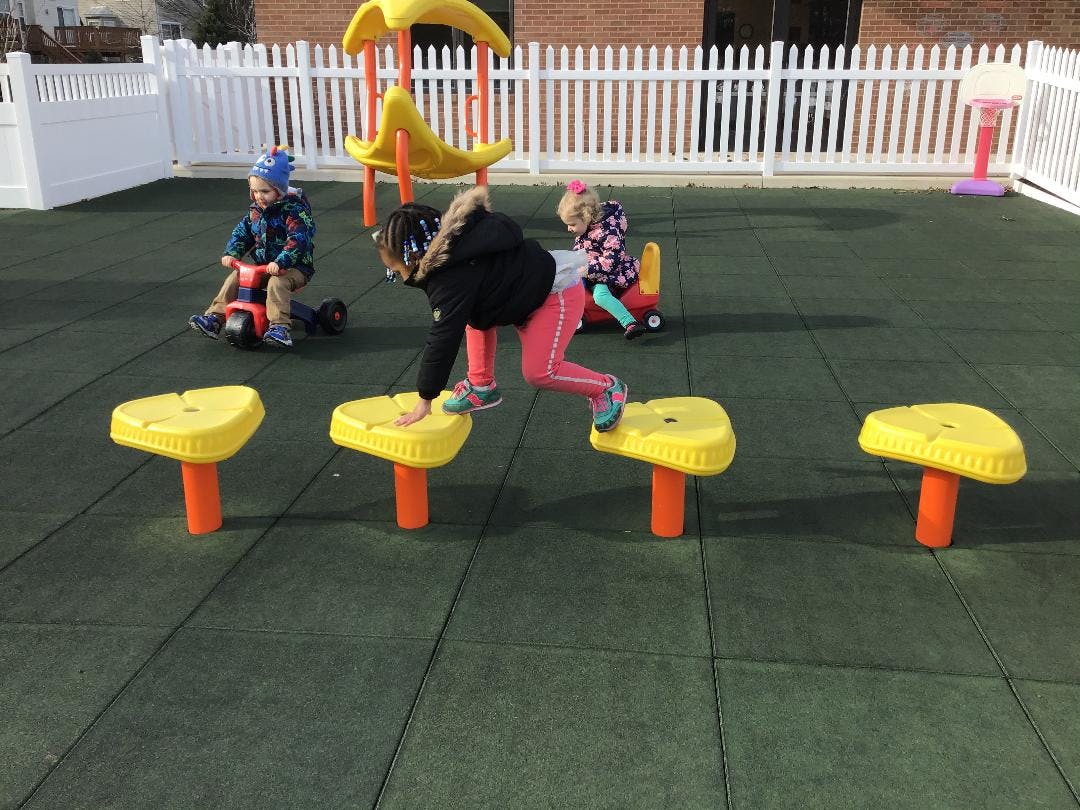 Children playing in a playground with one child on a step