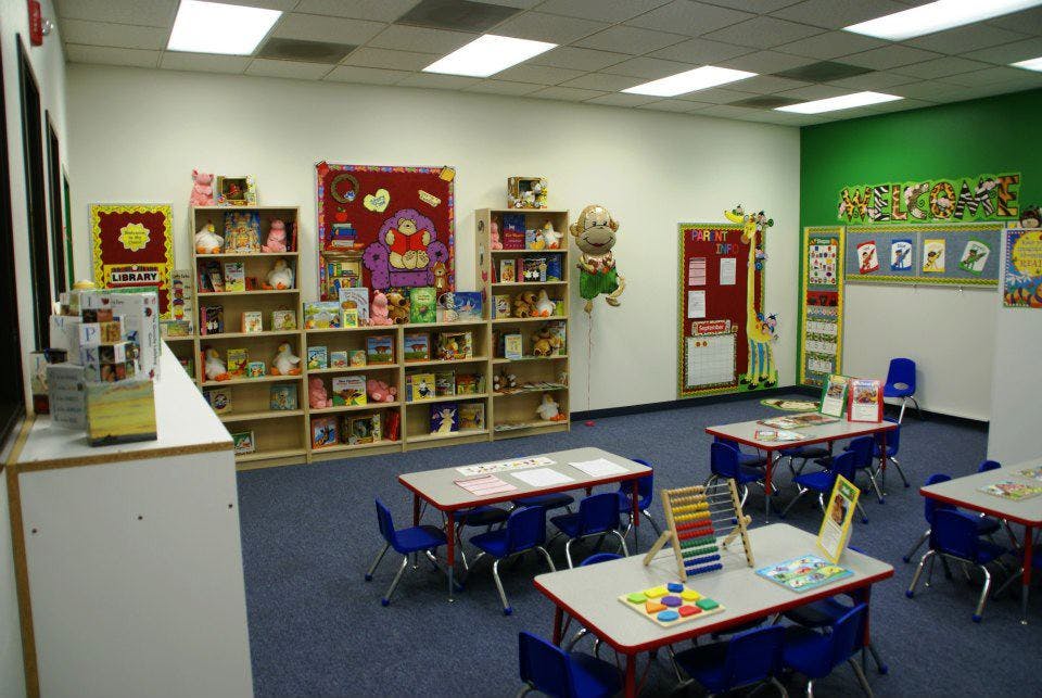 Classroom with small tables and chairs, bookshelves, and decorations