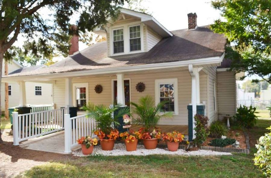 Small house with a porch and potted plants