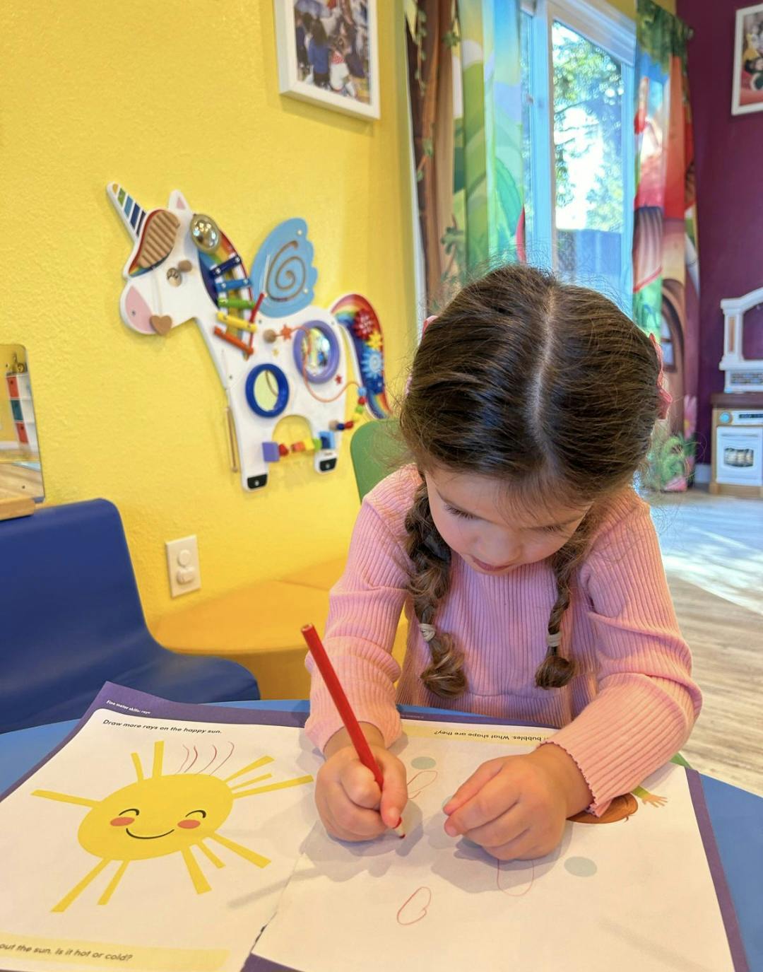 Child coloring in a workbook at a desk