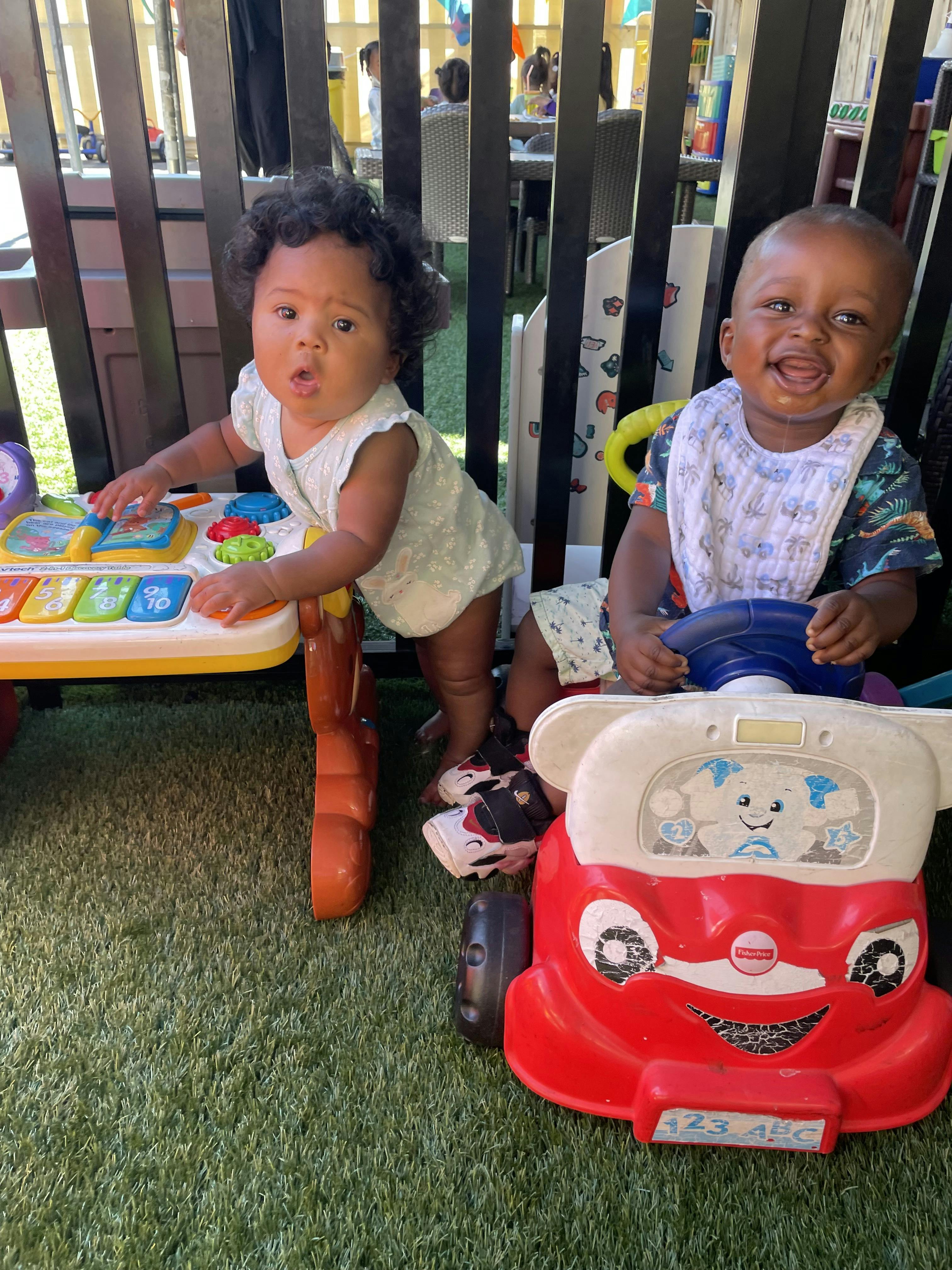 Two children playing with a toy table and a toy car
