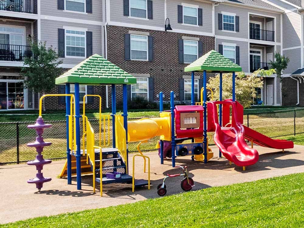 Colorful playground structure with slides and climbing areas in front of apartment buildings
