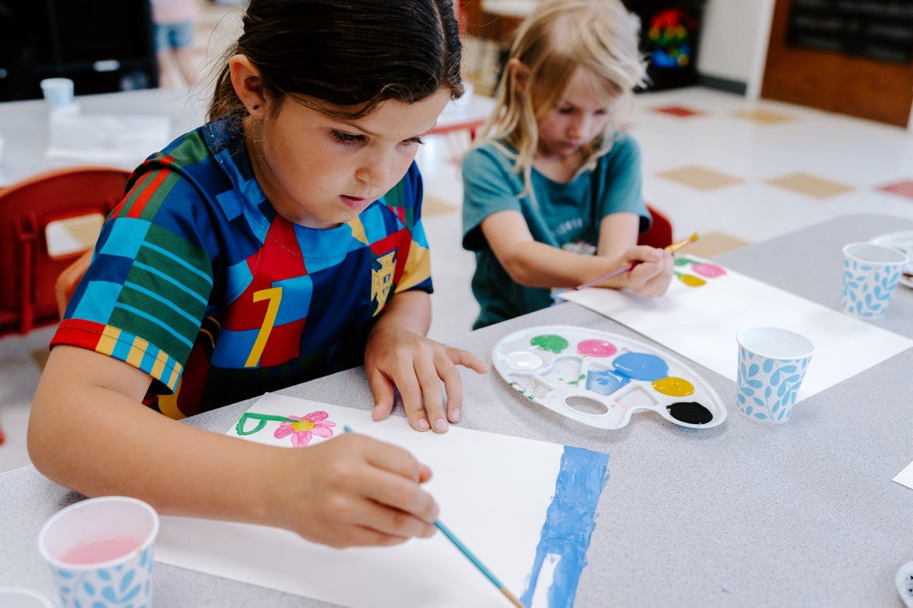 Two children painting at a table