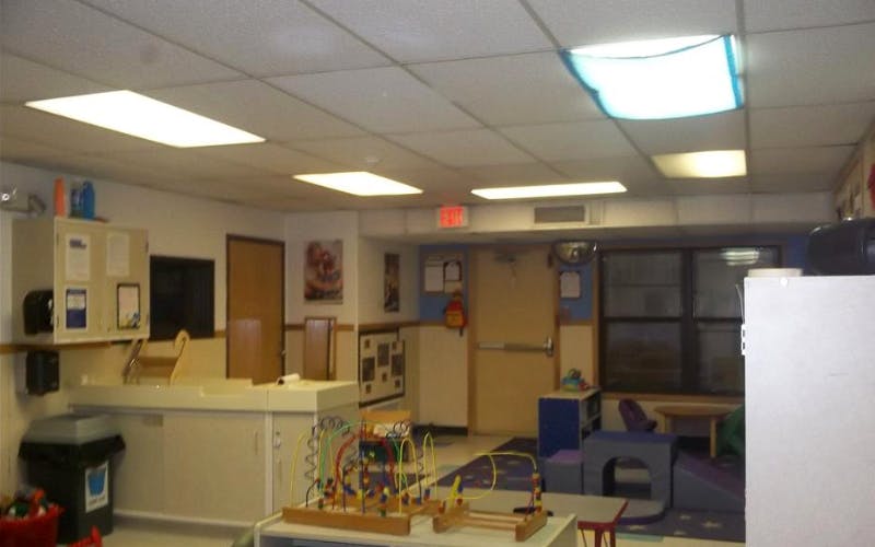 An empty childcare room with toys and changing station