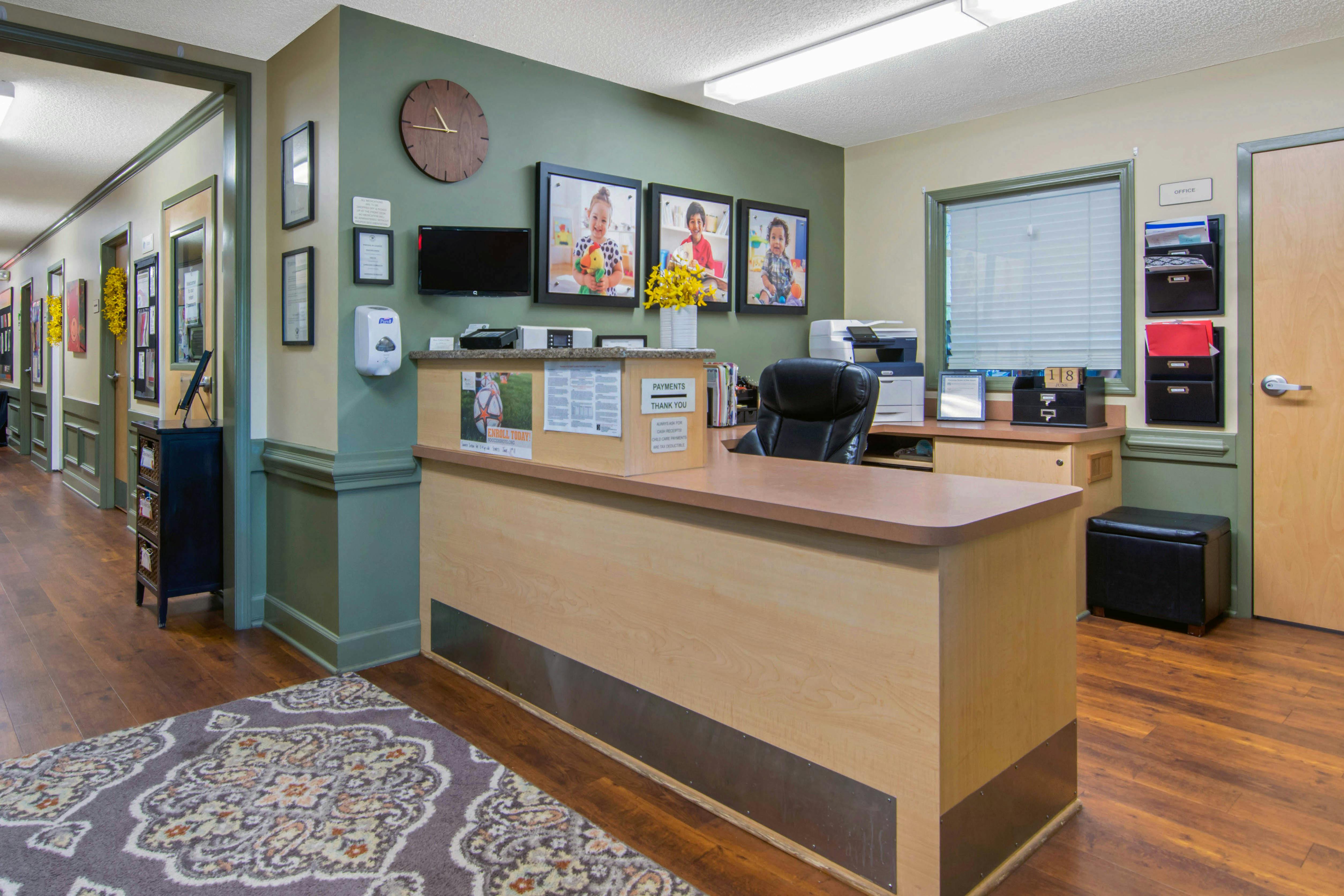reception desk in an office with child photos on the wall