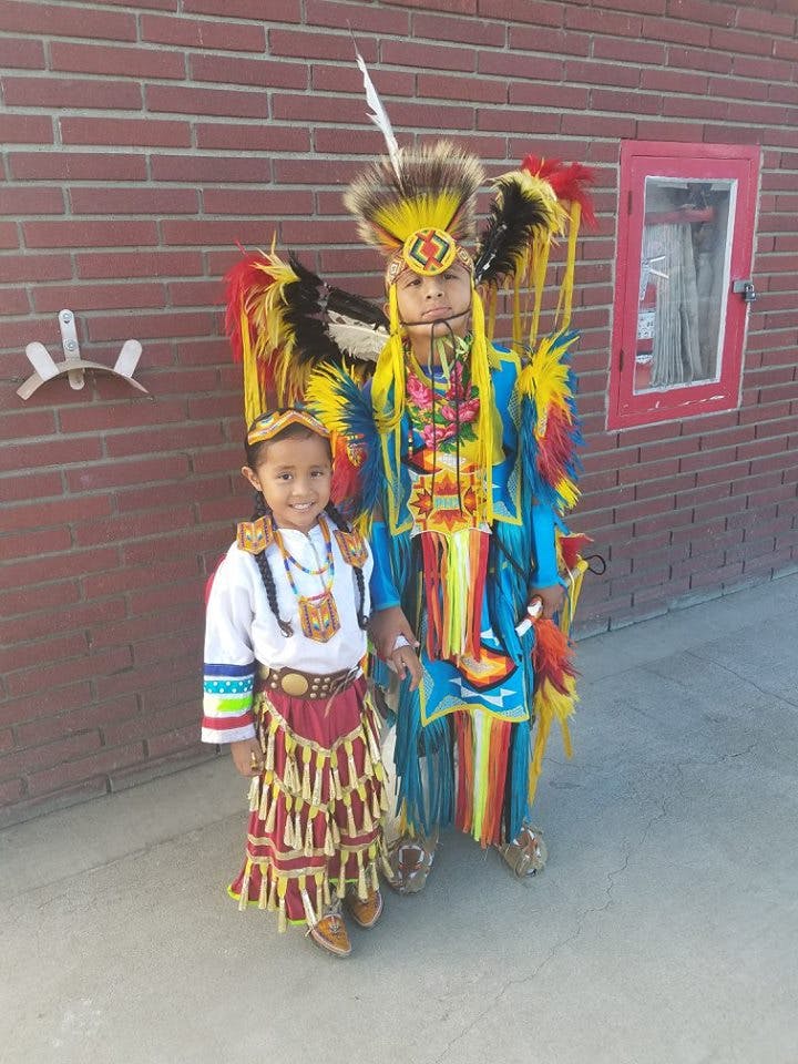 Two people in traditional regalia standing together
