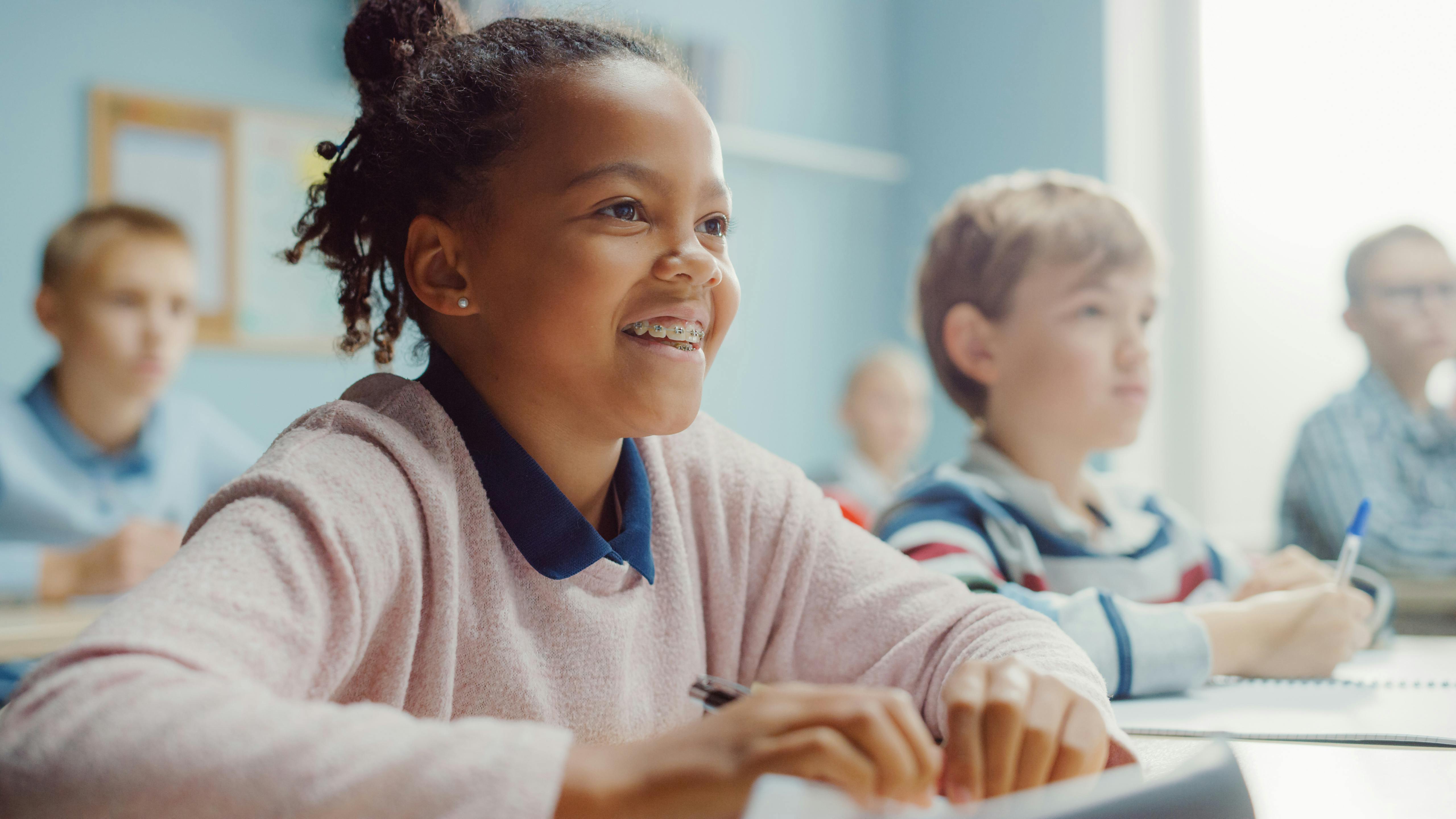 Child in a classroom with other students in the background