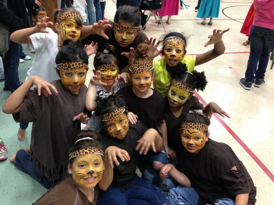 Group of children with painted faces and leopard print headbands