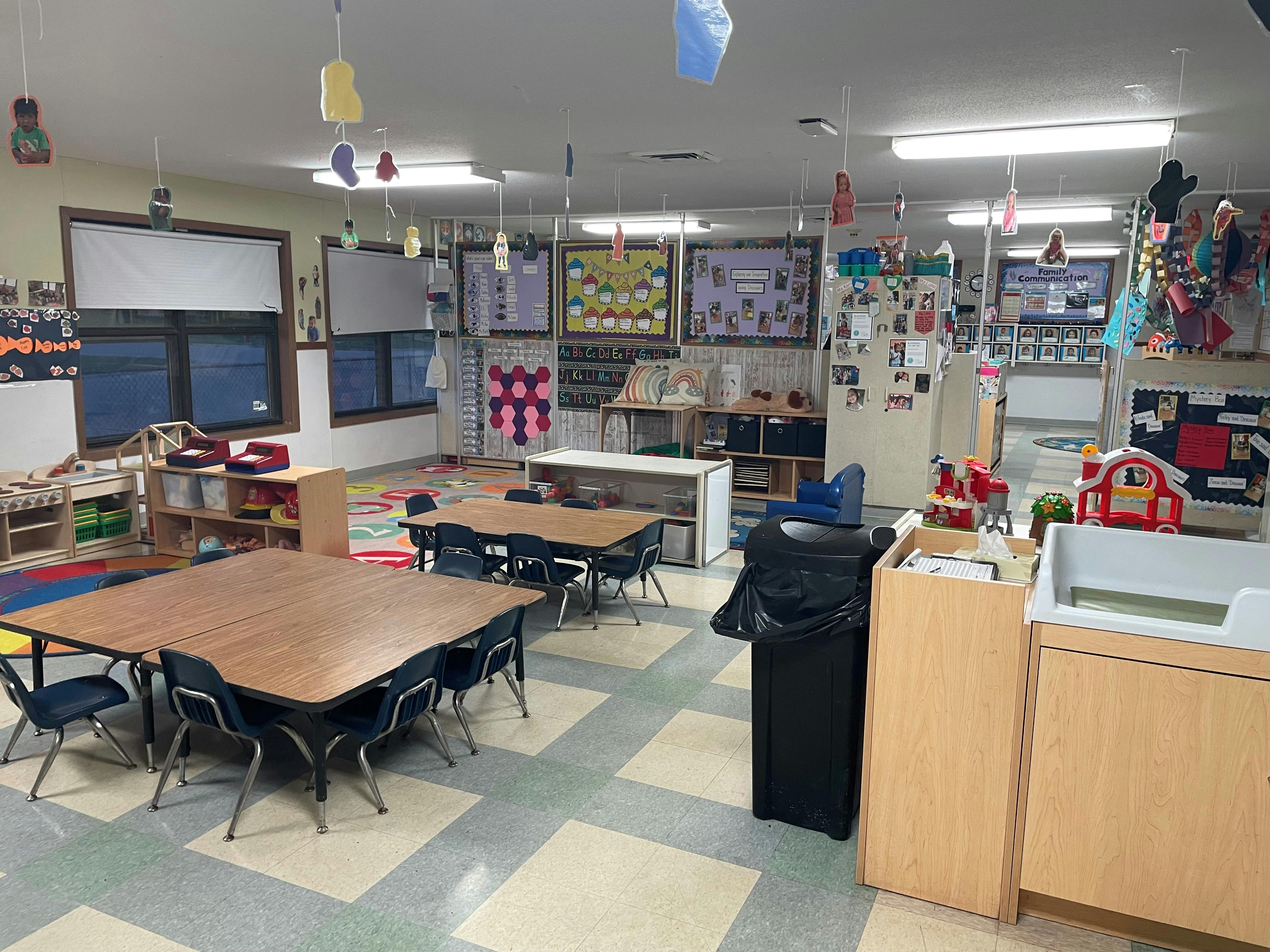 Classroom with tables, chairs, and decorations on the walls and ceiling