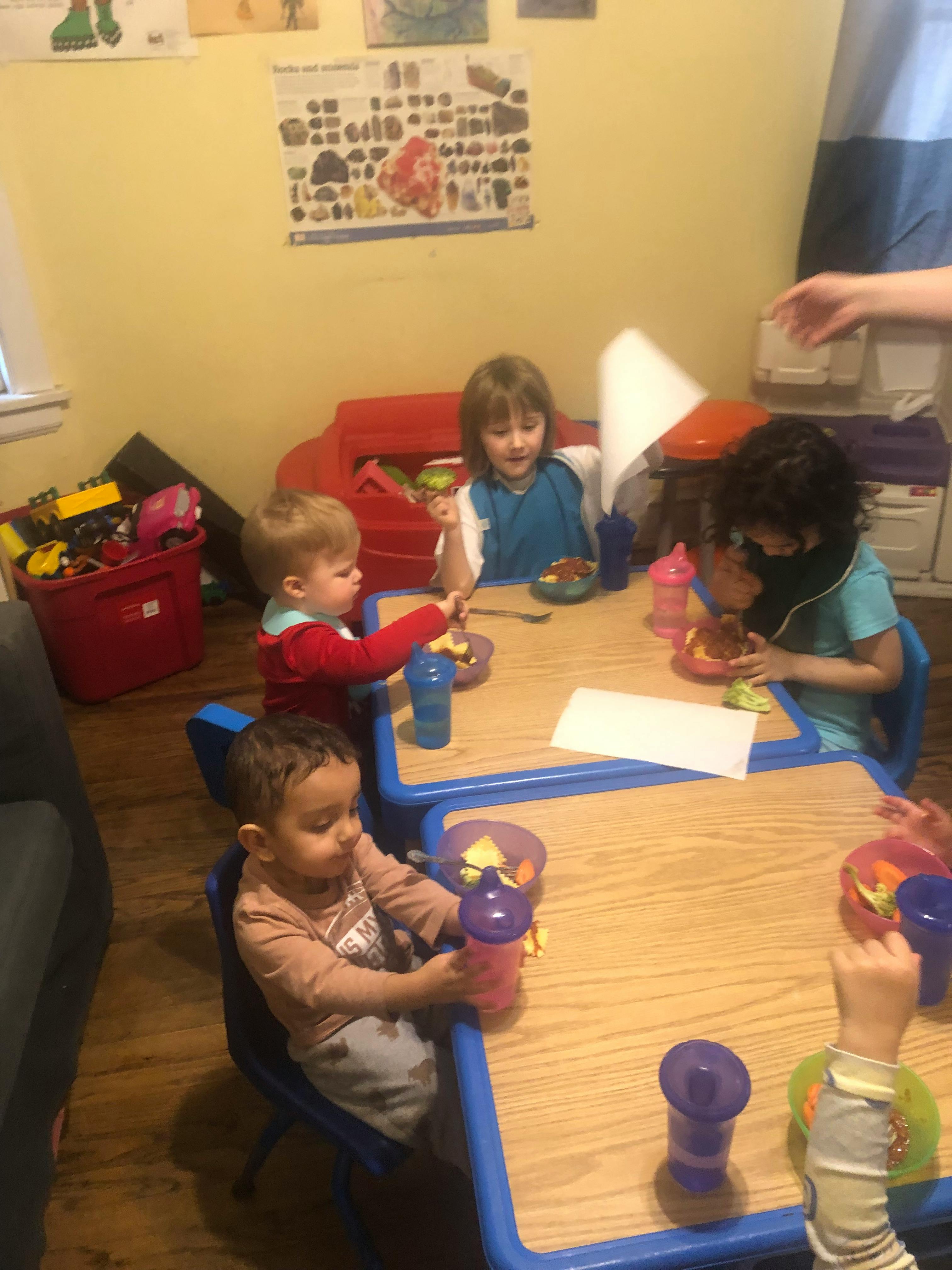 Children sitting at tables eating and drinking