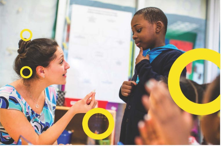 Adult speaking to a child in a classroom