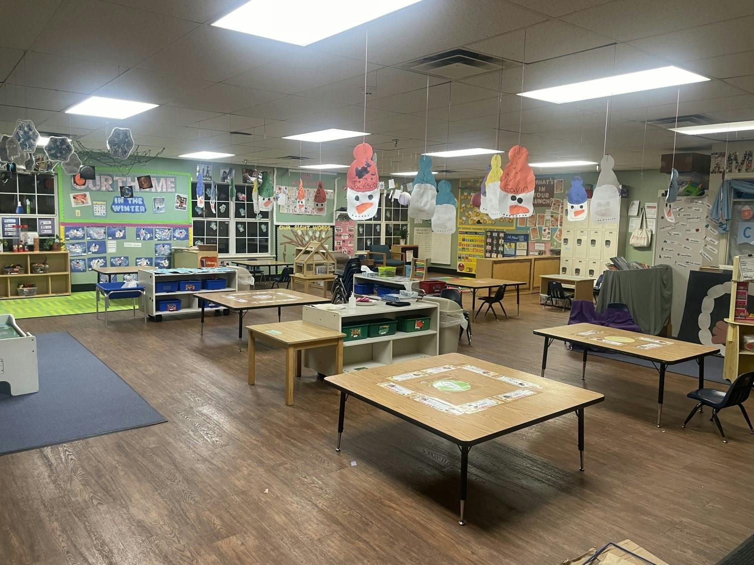 Empty classroom with small tables and chairs, winter-themed decorations
