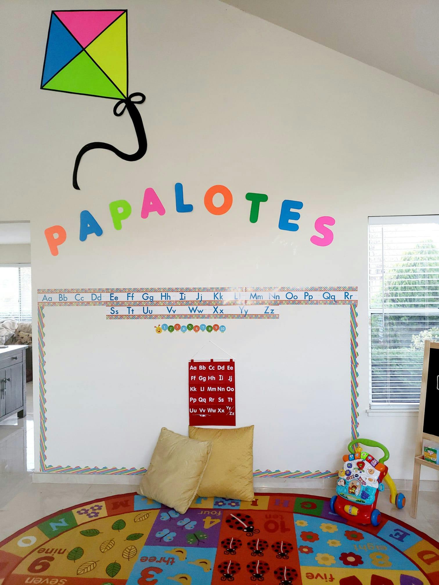 Classroom with a whiteboard, alphabet, and colorful rug