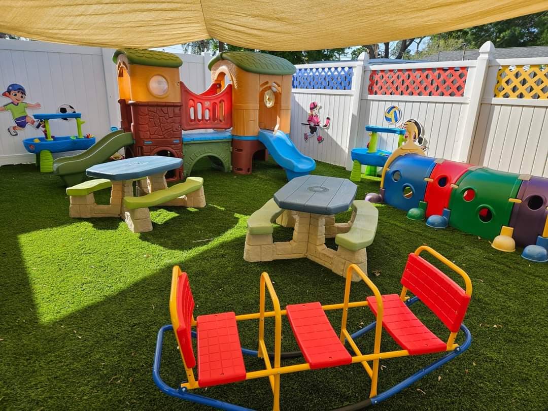 Outdoor playground with slides, tables, and a colorful tunnel