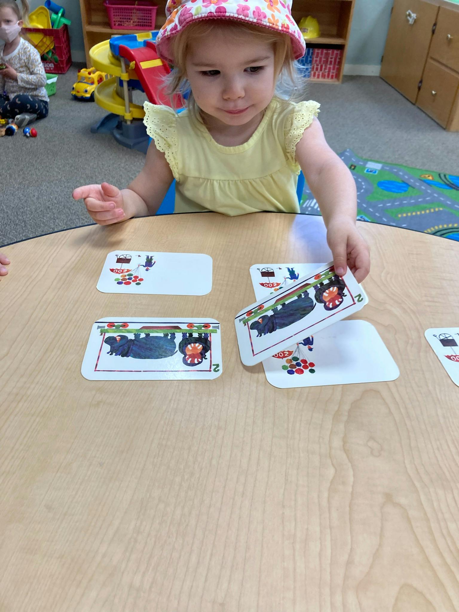 Child playing with cards at a table