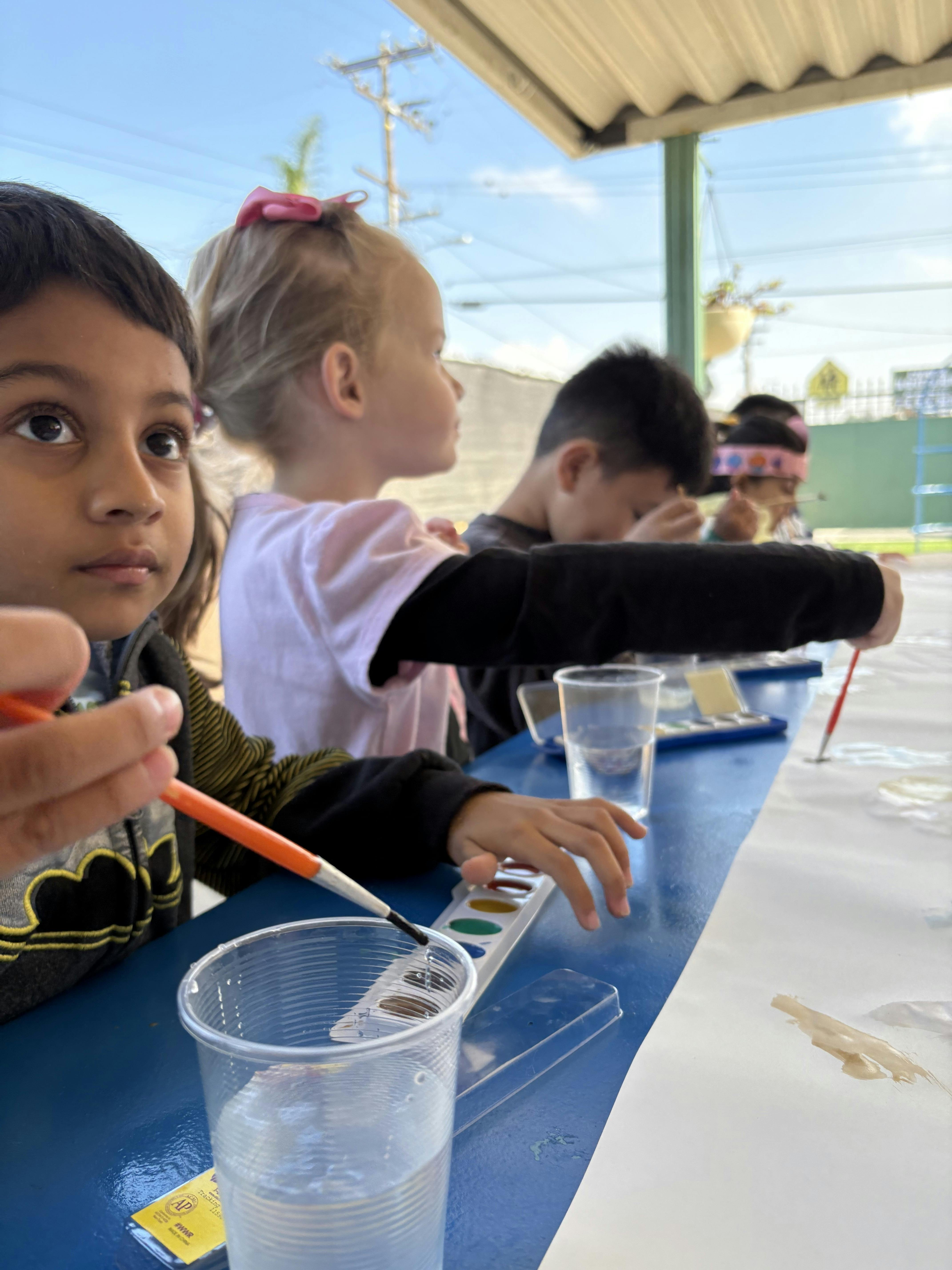 Children painting with watercolors outdoors