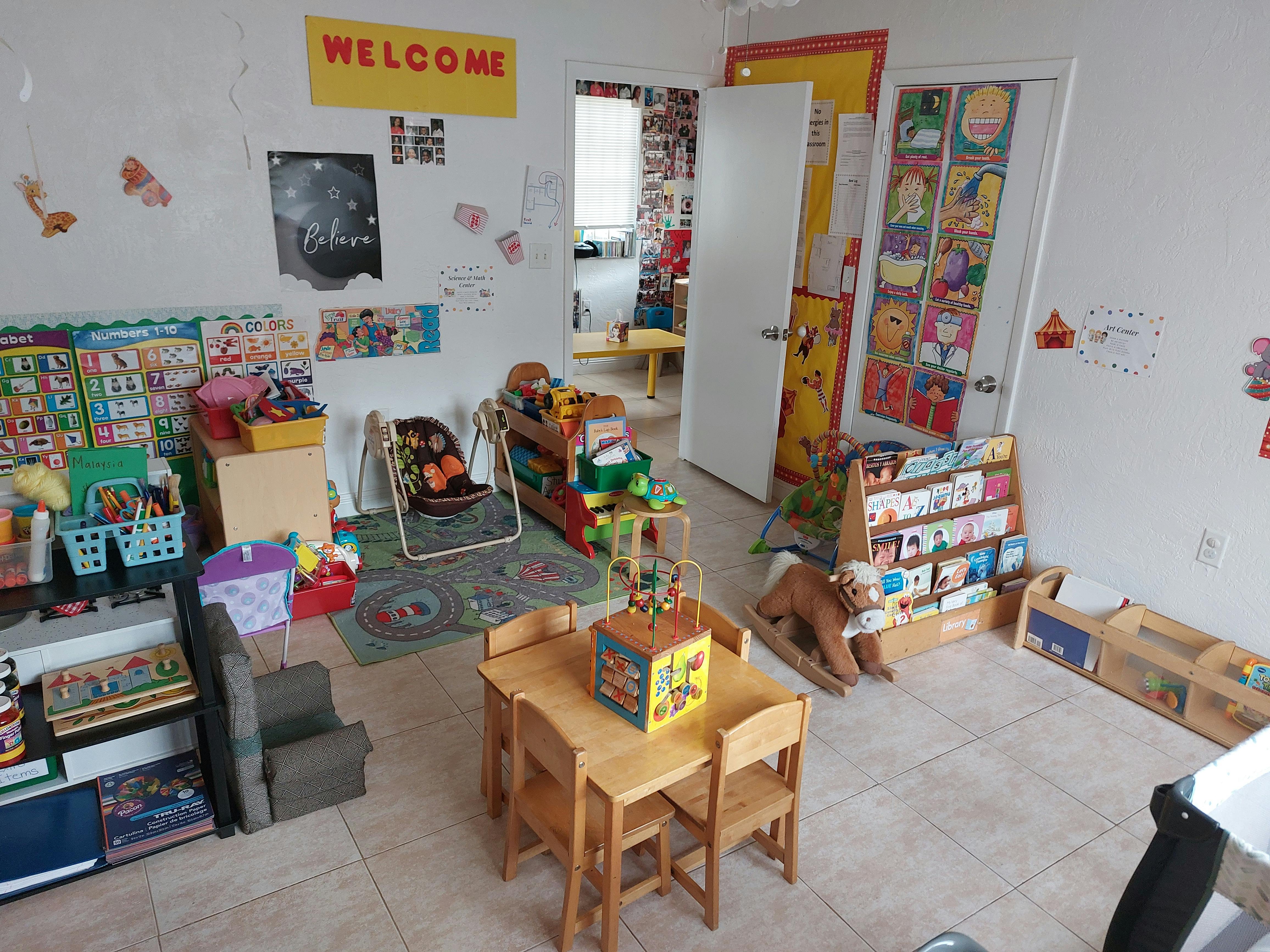 A classroom with small tables and chairs, toys, and learning materials