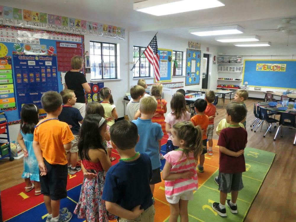 Adult speaking to a group of children in a classroom
