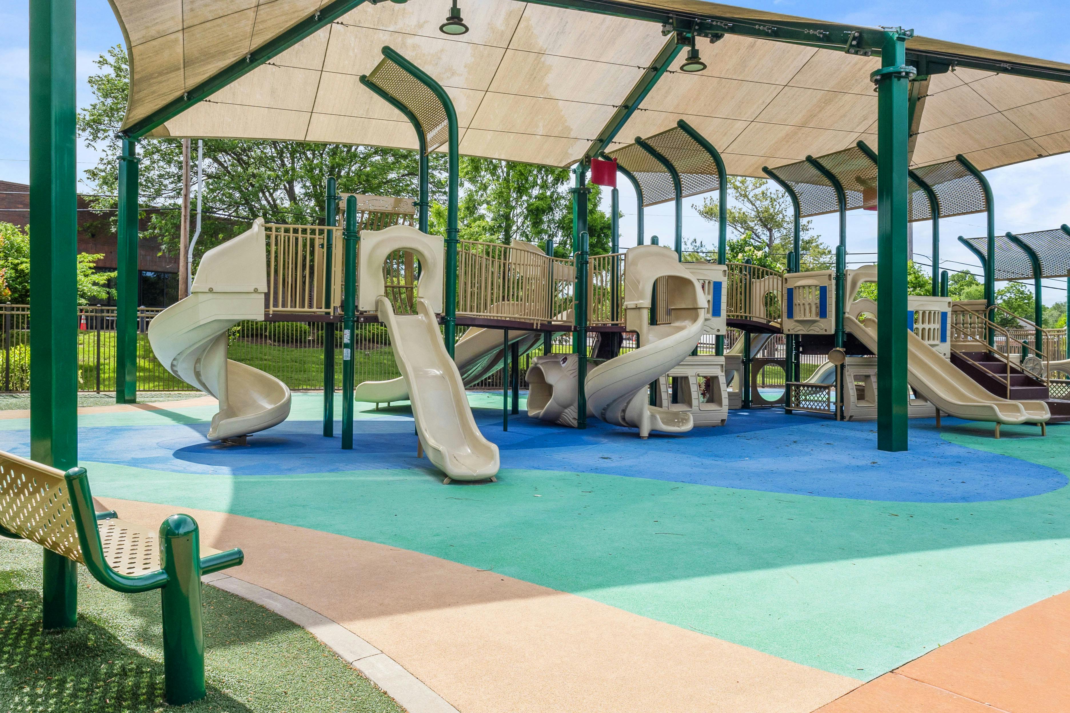 A covered outdoor playground with multiple slides and climbing structures