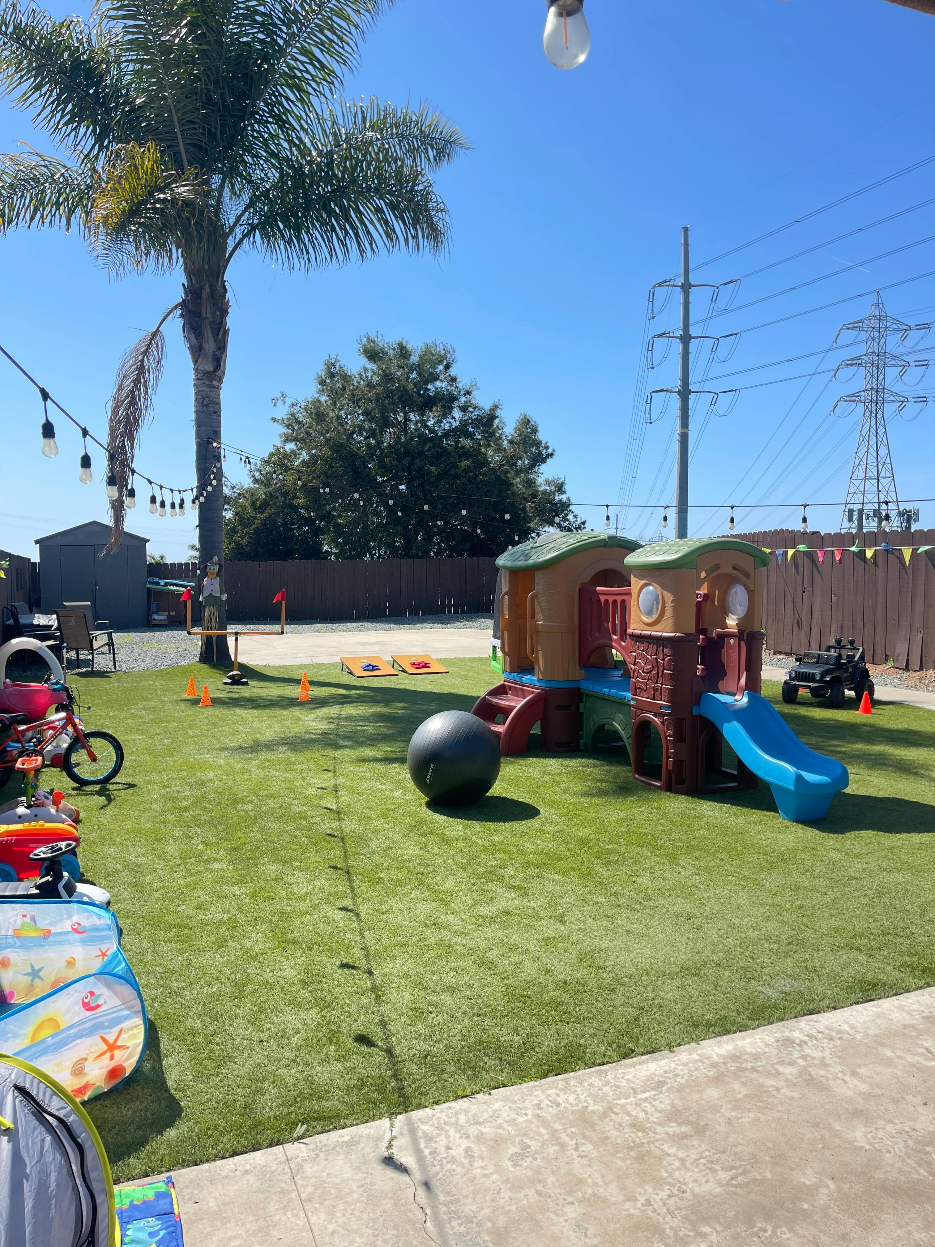 Playground with a small slide and playhouse on artificial grass
