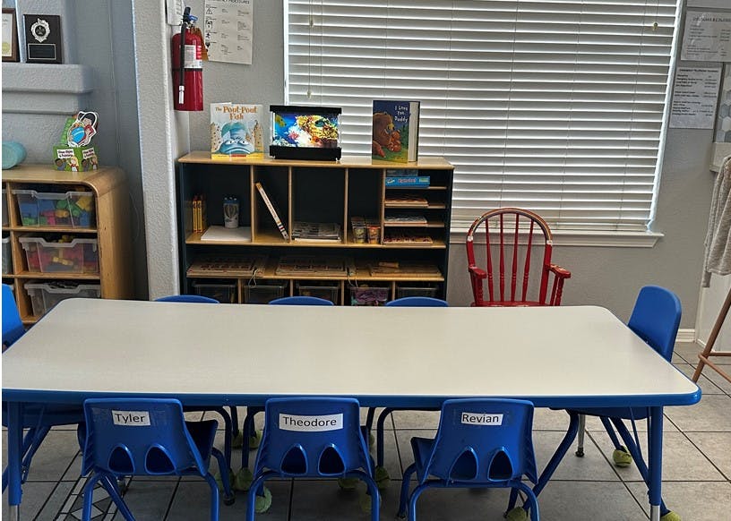 Empty classroom with a long table and blue chairs