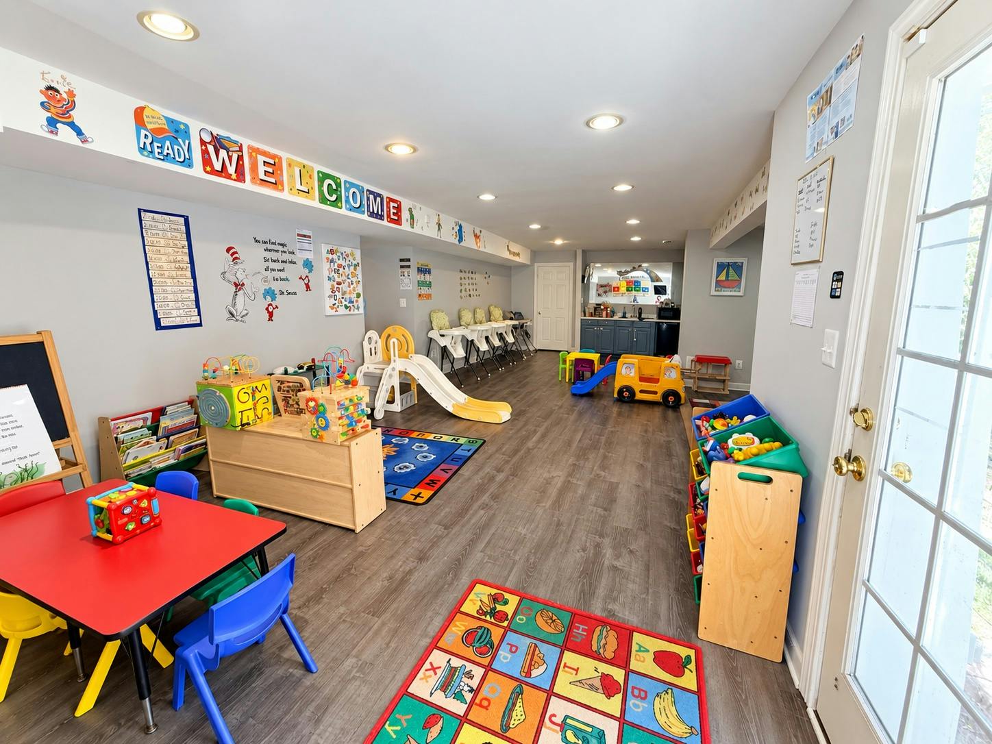 Colorful playroom with activity tables chairs toys and a small slide