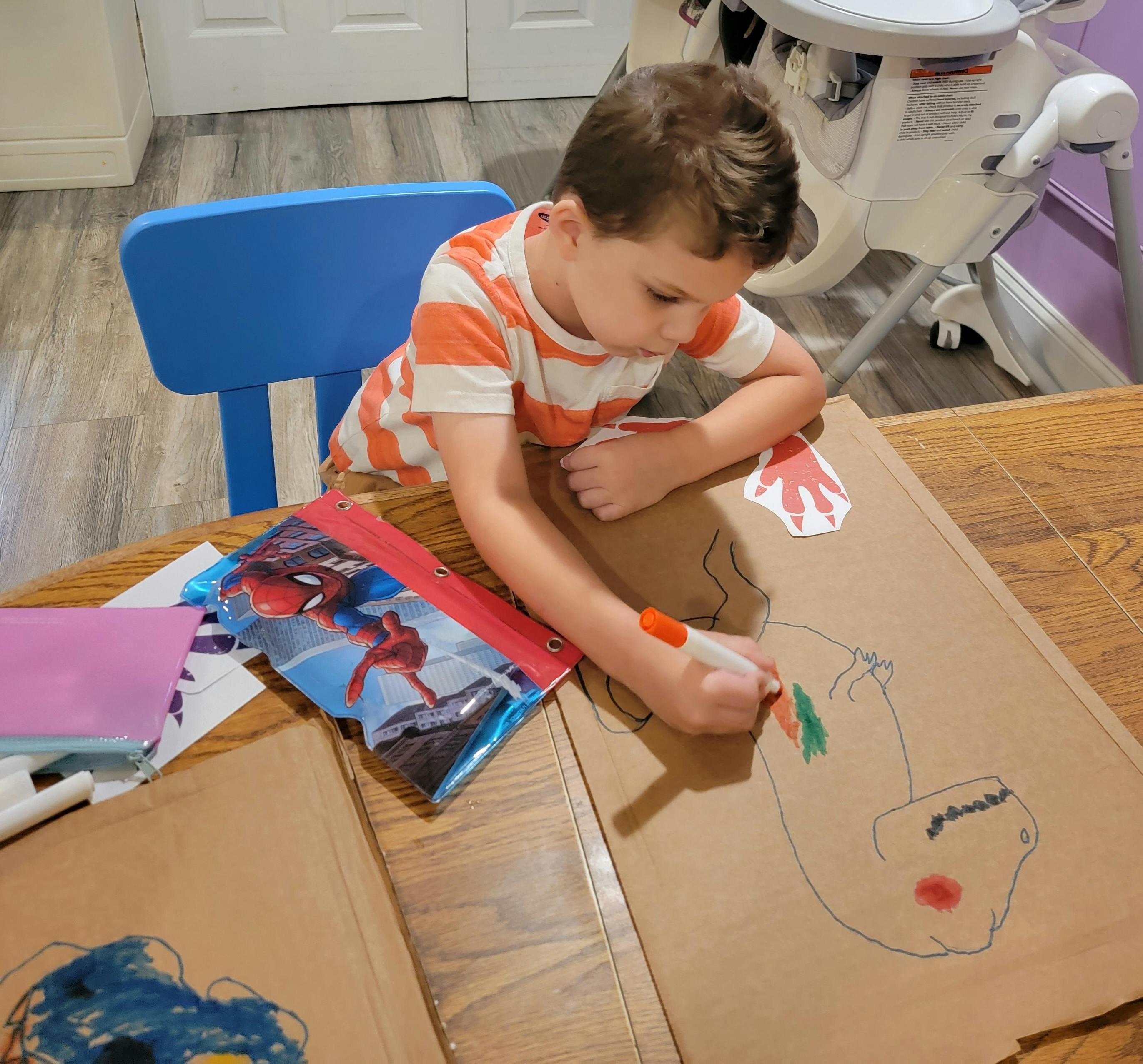Child drawing on cardboard with a marker