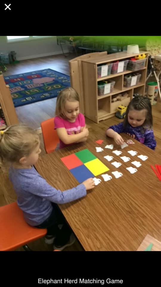 Three children playing a matching game at a table