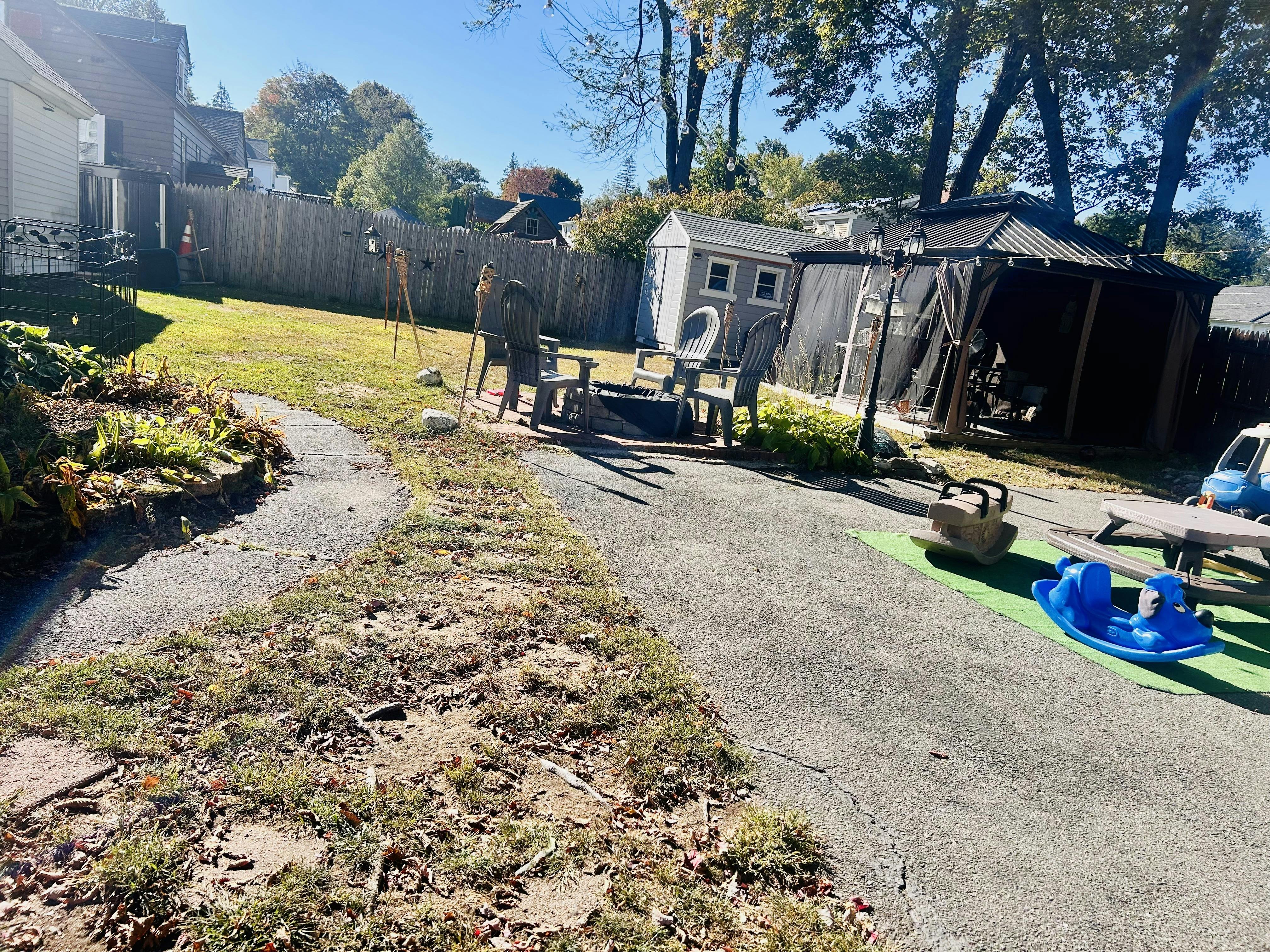 Backyard with a shed, gazebo, and fire pit area