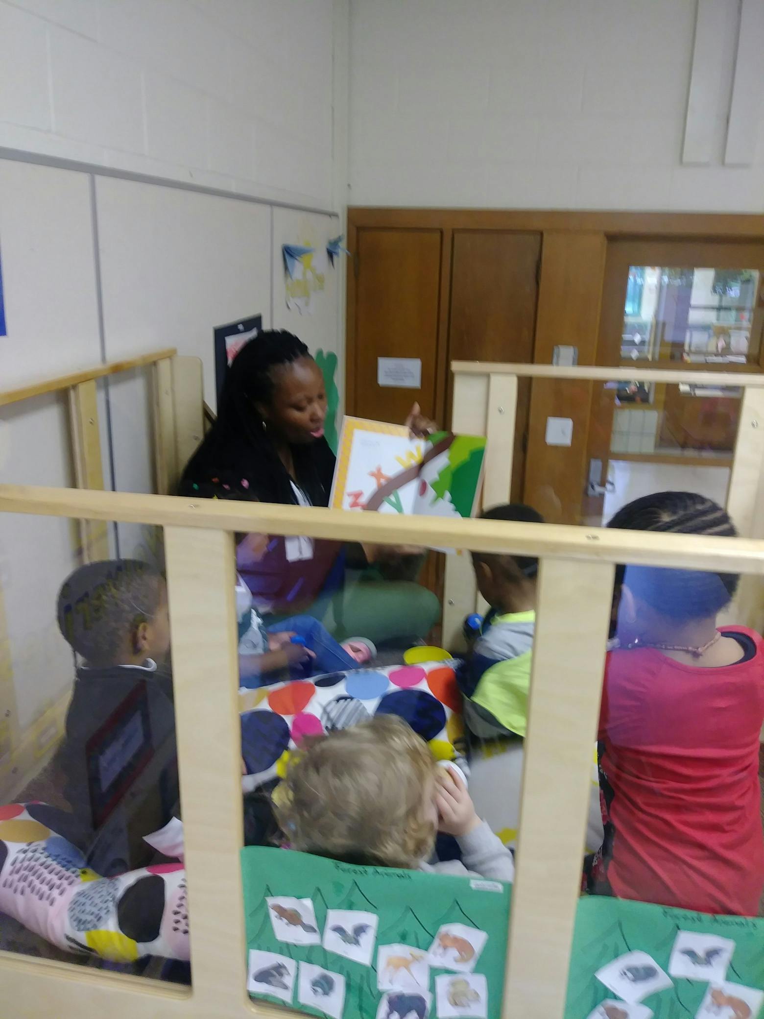 Person reading a book to children in a classroom