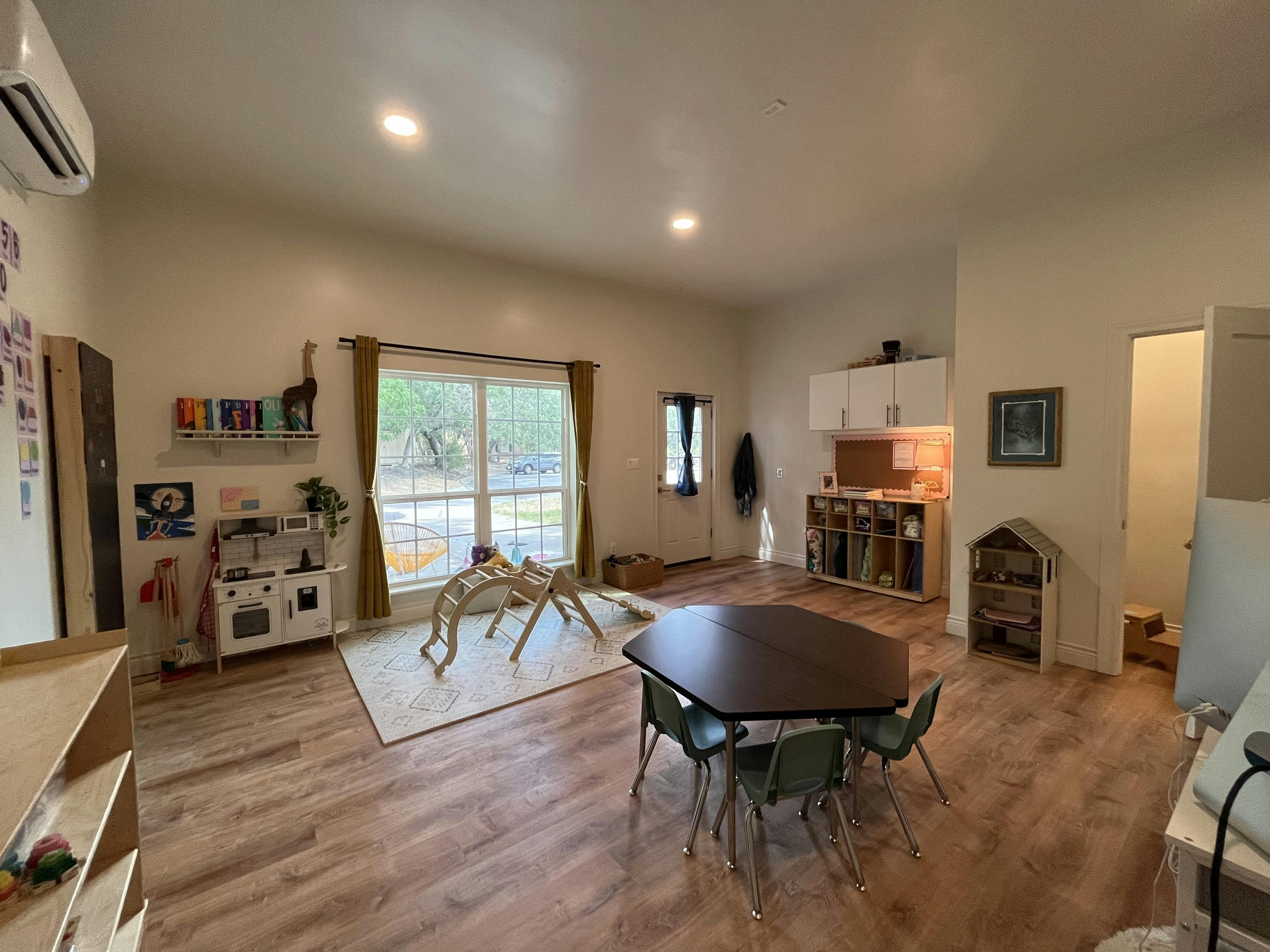 Playroom with a small table and chairs, play kitchen, and climbing structure